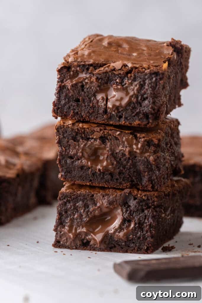 Two fudgy brown butter brownies stacked, showing their thick, decadent layers