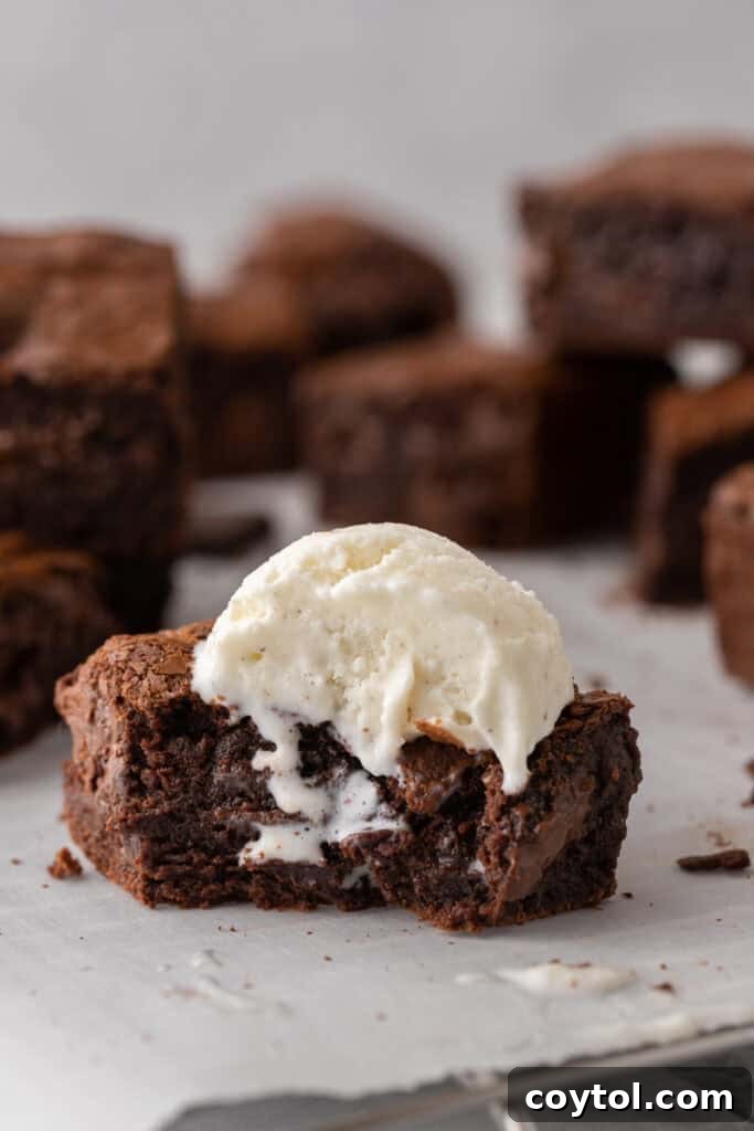 A fudgy brown butter brownie topped with a scoop of vanilla ice cream