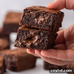 Hand holding fudgy brown butter brownies