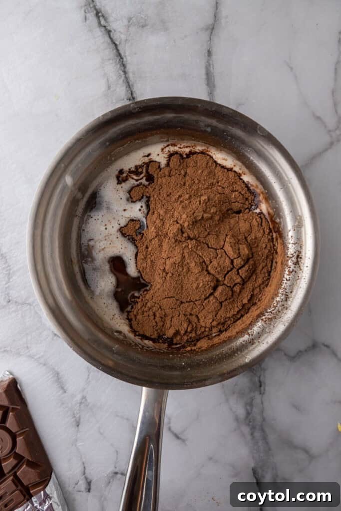 Cocoa powder and chocolate being stirred into browned butter