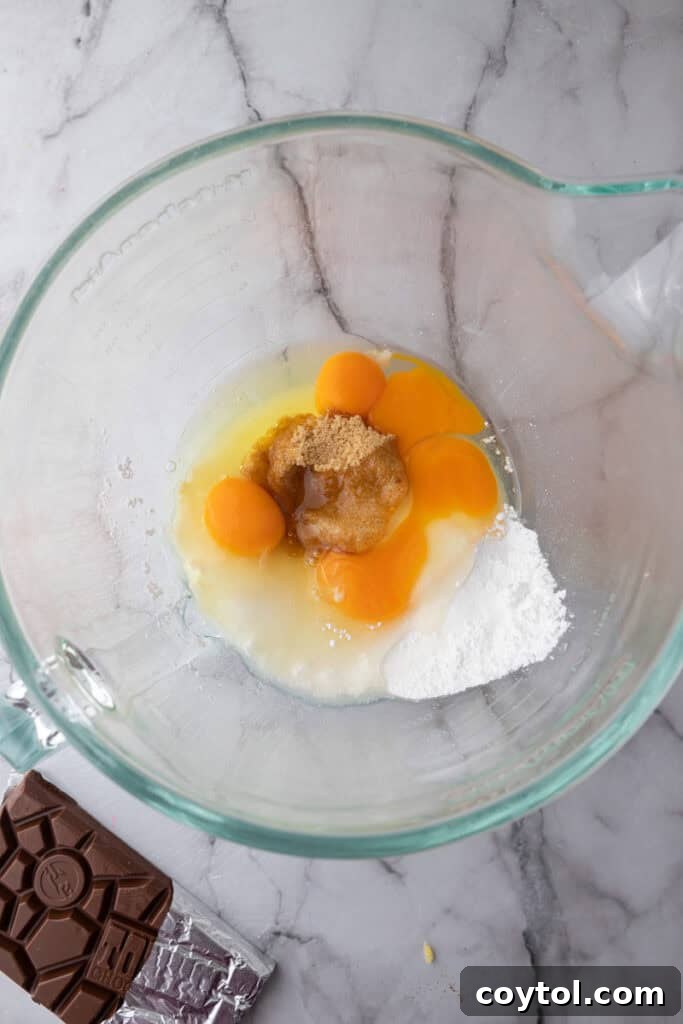 Eggs and sugars in a mixing bowl before beating