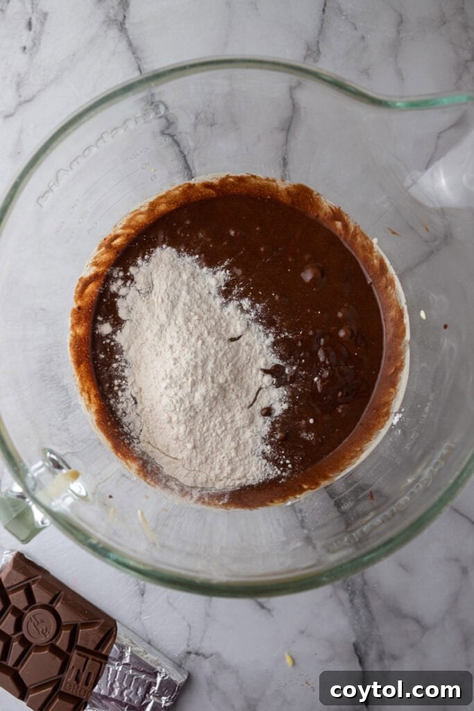 Cooled chocolate-butter mixture being added to whipped eggs