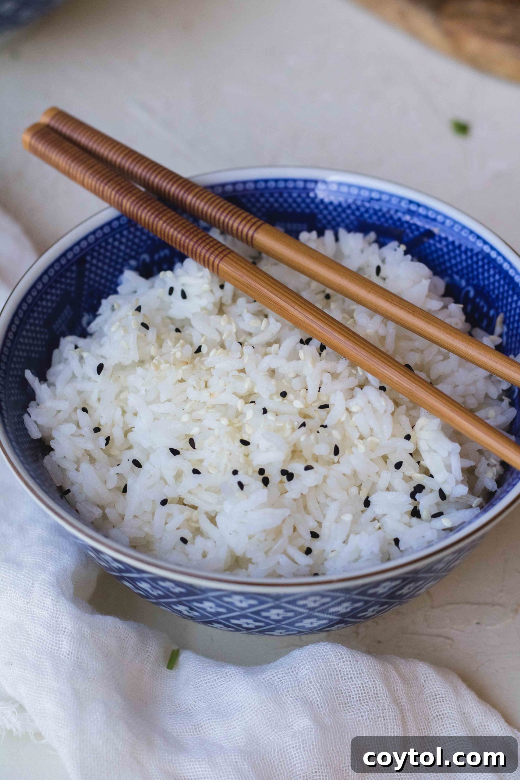 Pot of cooked white rice on the stovetop with a wooden spoon