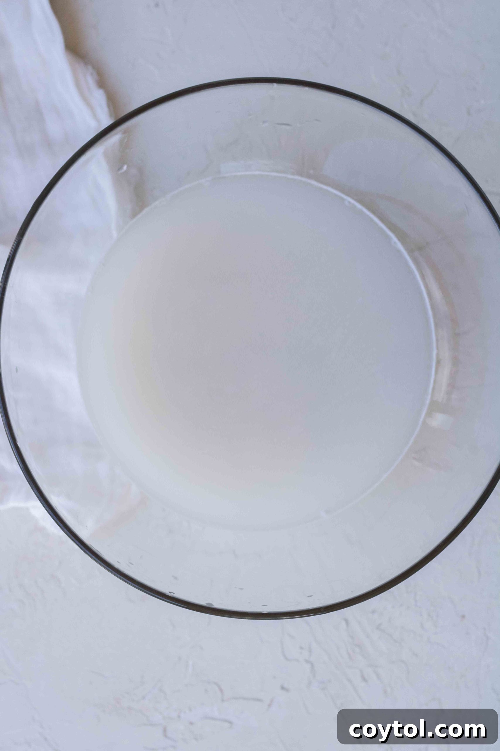 White rice grains being rinsed in a sieve