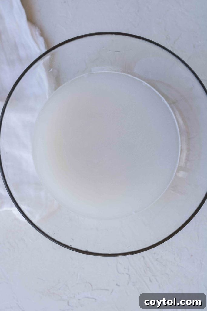 Rinsed white rice in a sieve ready for cooking