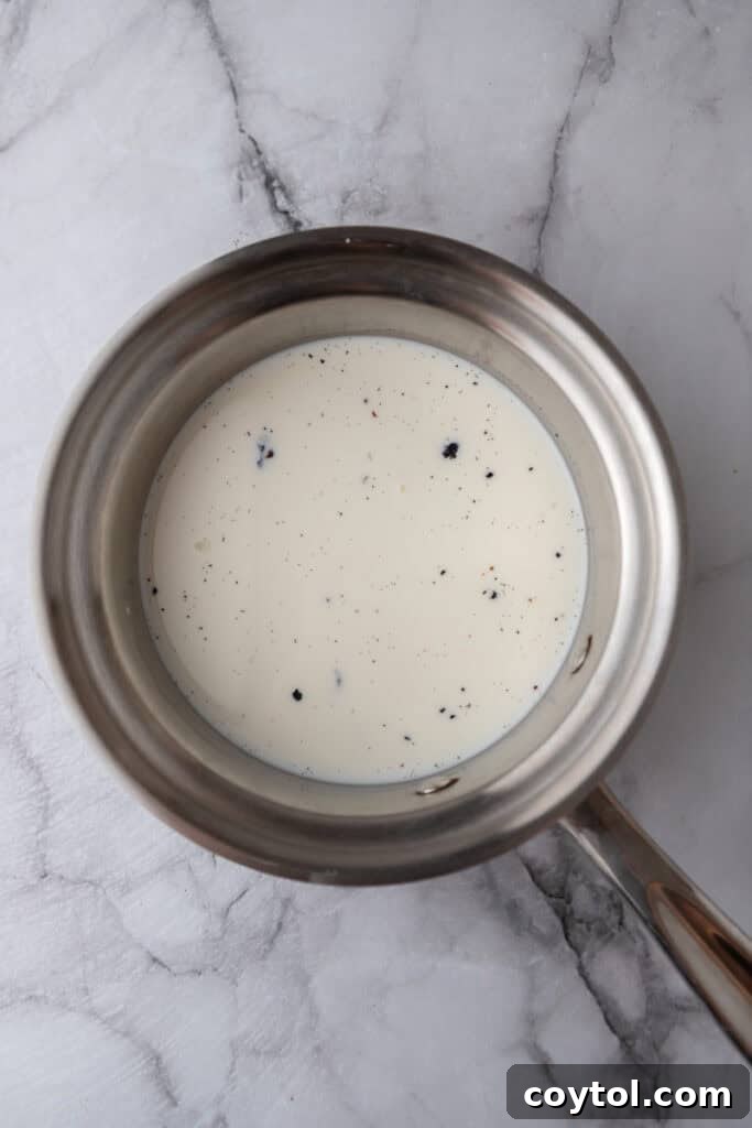 Velvet Vanilla Custard Ice Cream Made Simple 5 heavy cream and milk in a pot with vanilla bean infusing