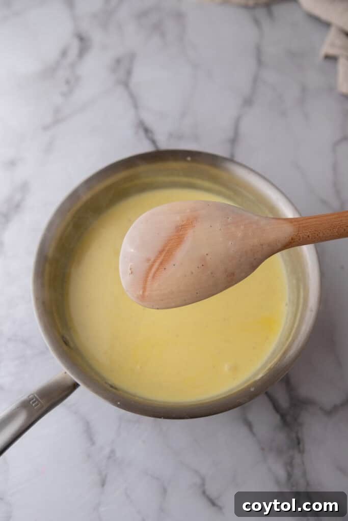 Velvet Vanilla Custard Ice Cream Made Simple 10 custard mixture coating the back of a wooden spoon, indicating it's ready