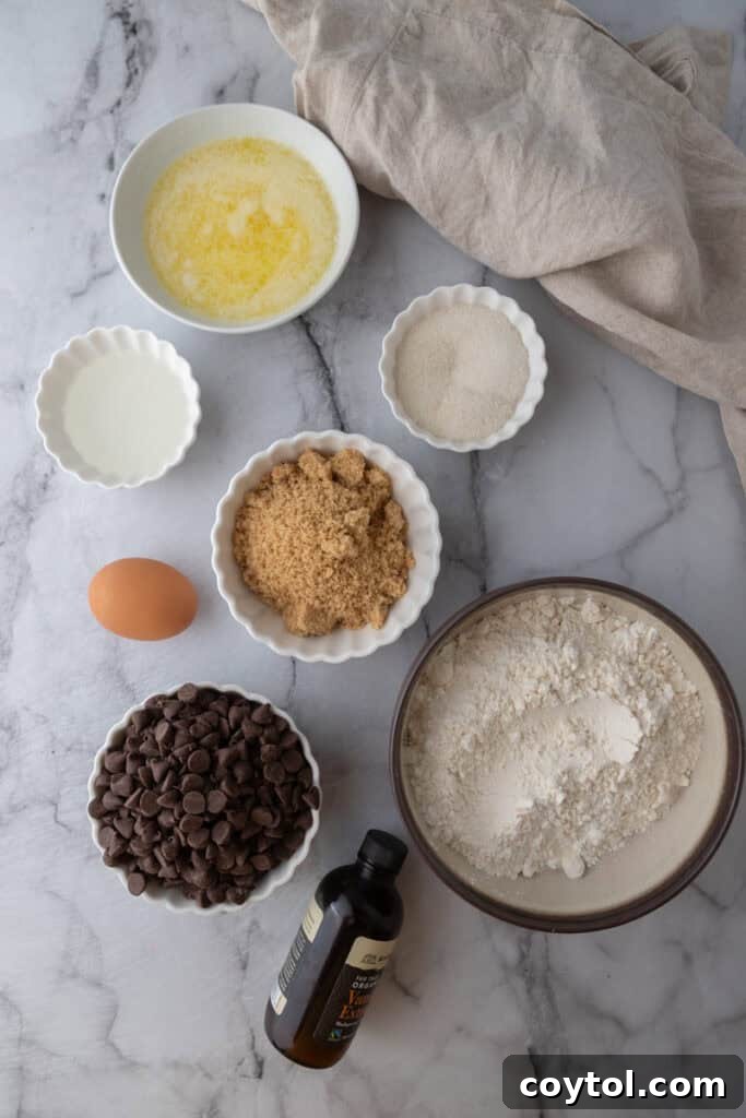 The Ultimate Homemade Chocolate Chip Cookie Cake 3 All the dry and wet ingredients for the chocolate chip cookie cake recipe laid out on a kitchen counter, ready for mixing.