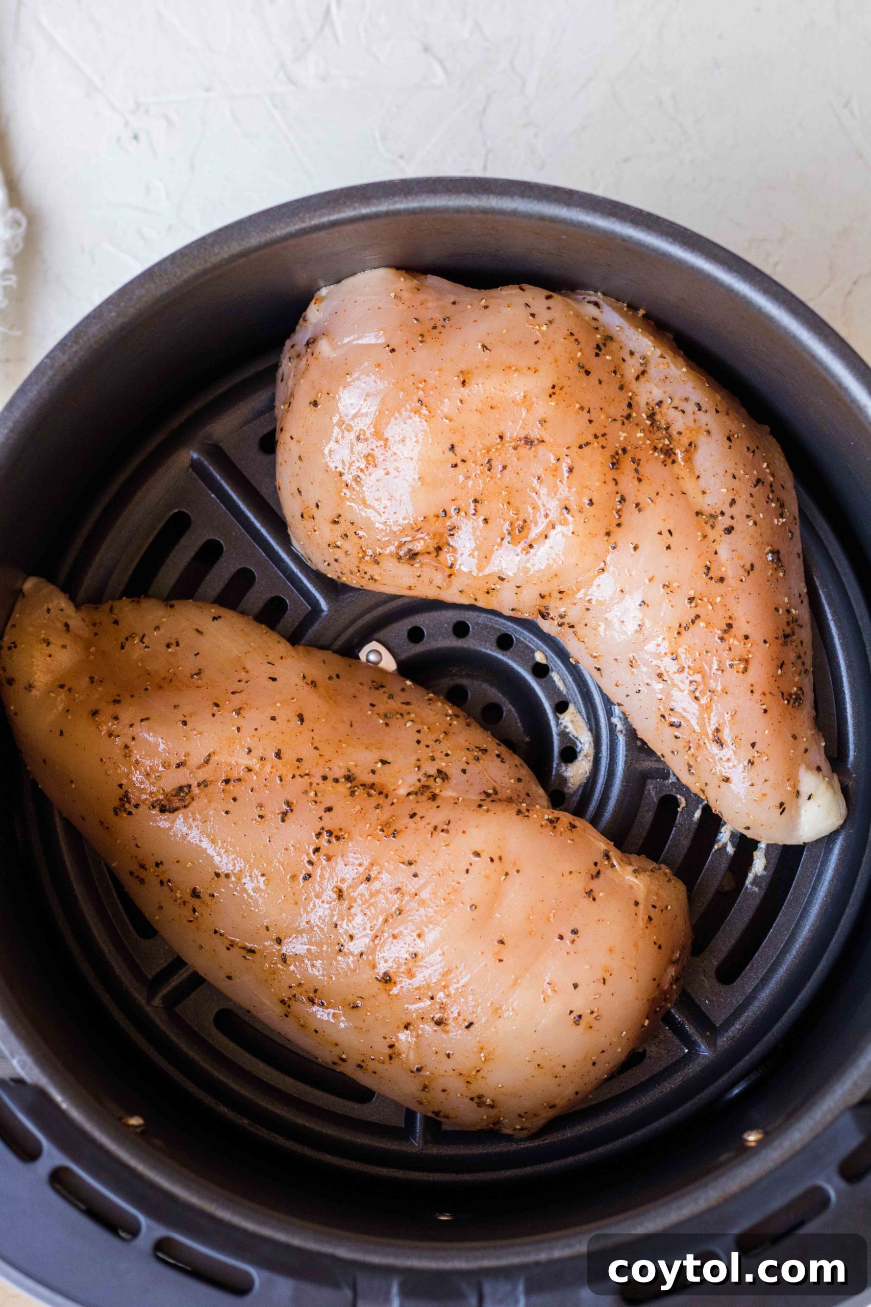 Preheating the air fryer for optimal chicken breast cooking.