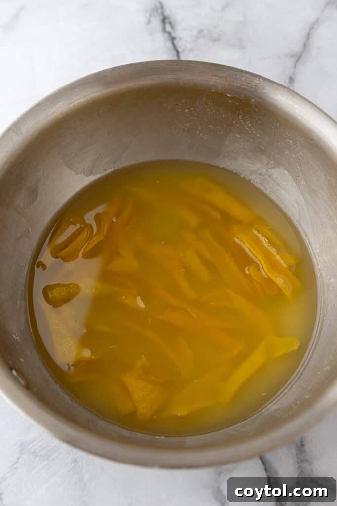 Straining lemon simple syrup into a pitcher