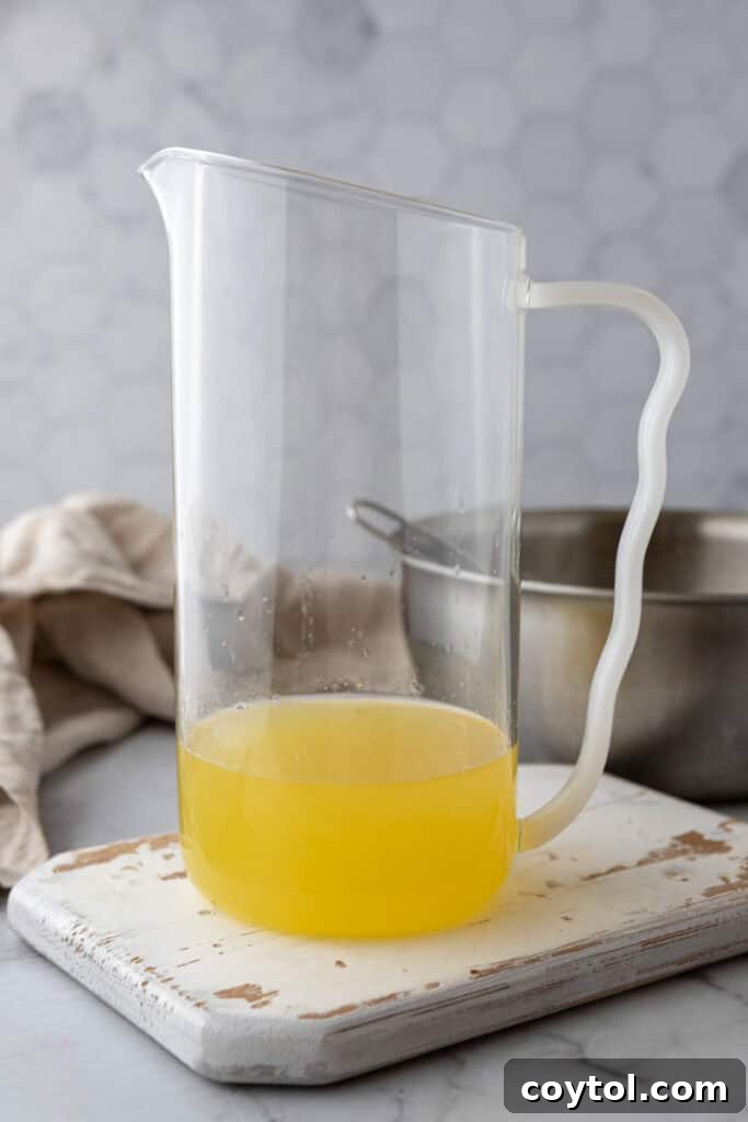 Adding water to lemon simple syrup in a pitcher