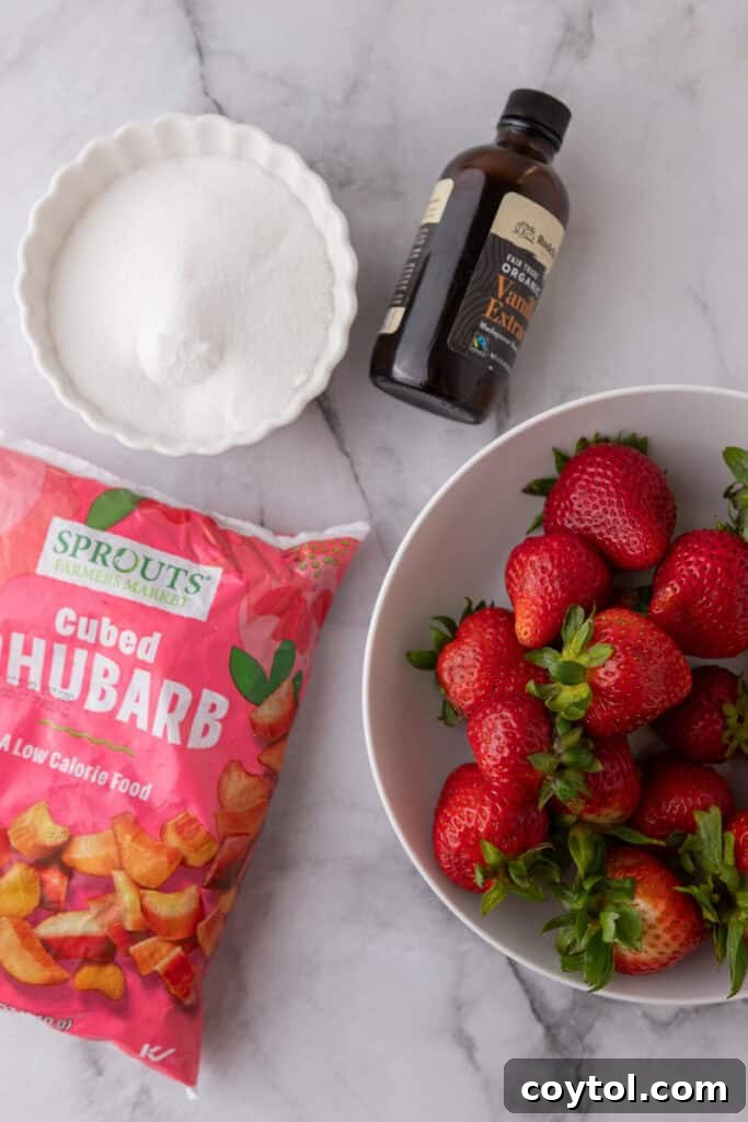 Homemade Strawberry Rhubarb Jam Without Pectin 3 Ingredients for strawberry rhubarb jam laid out on a surface, including fresh strawberries and rhubarb.