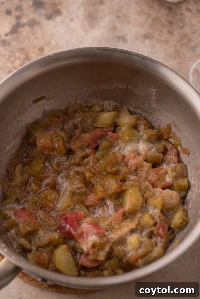 Rhubarb sauce simmering, showing a thicker consistency.