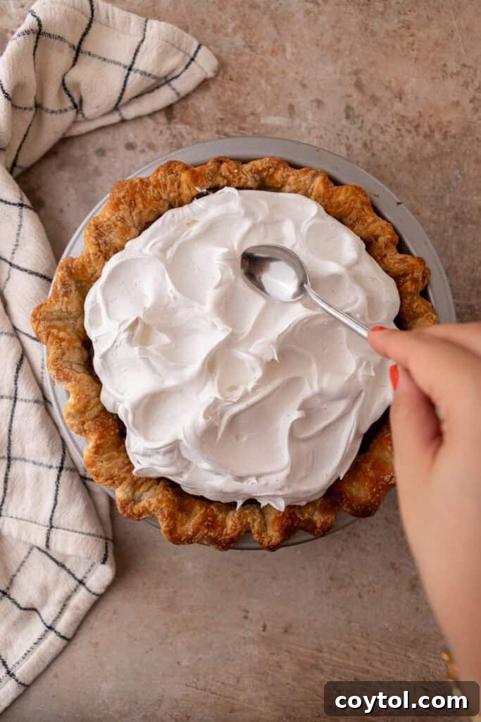 Fluffy Chocolate Meringue Pie Perfection 17 topping being spread onto filling