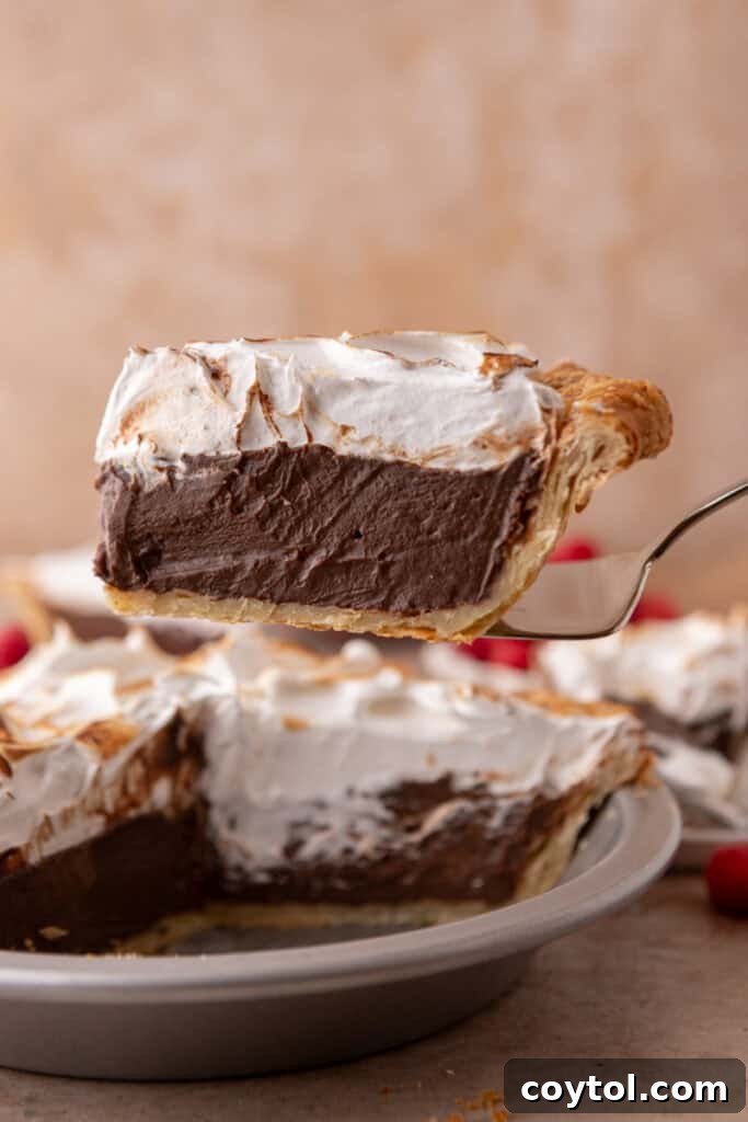 Fluffy Chocolate Meringue Pie Perfection 21 chocolate meringue pie slice on a serving spatula