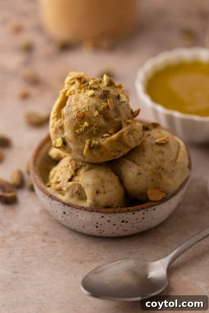 Crafting the Ultimate Homemade Pistachio Ice Cream 4 A scoop of homemade pistachio ice cream in a white bowl, garnished with chopped pistachios