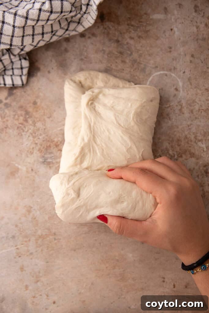 Dough being rolled up vertically to form a pre-shape.