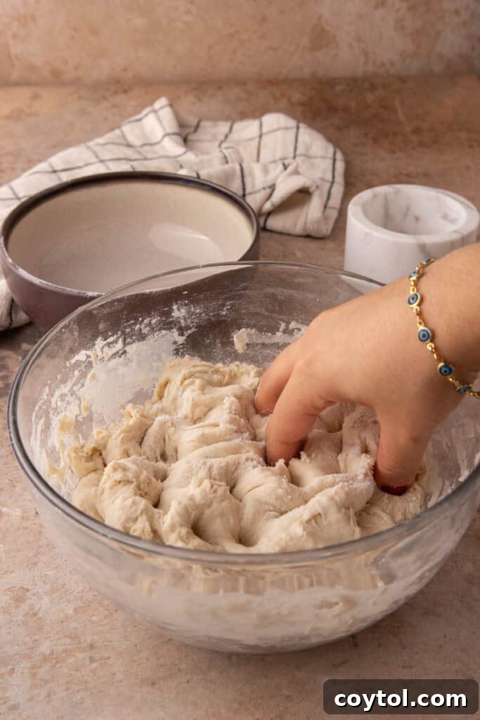Sourdough dough in a bowl after salt incorporation, covered for resting.