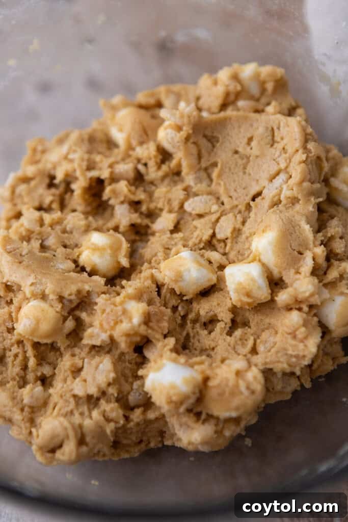 A bowl of rice krispy marshmallow cookie dough, ready to be scooped.