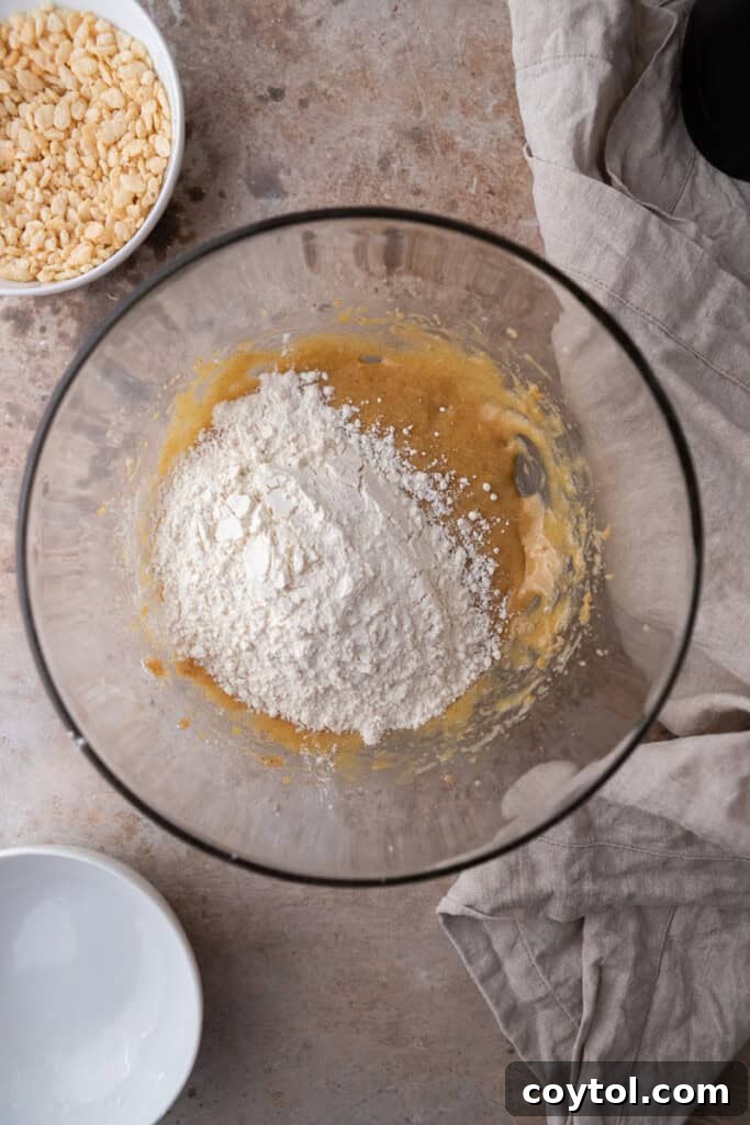 Wet ingredients in a bowl with dry flour mixture partially incorporated.