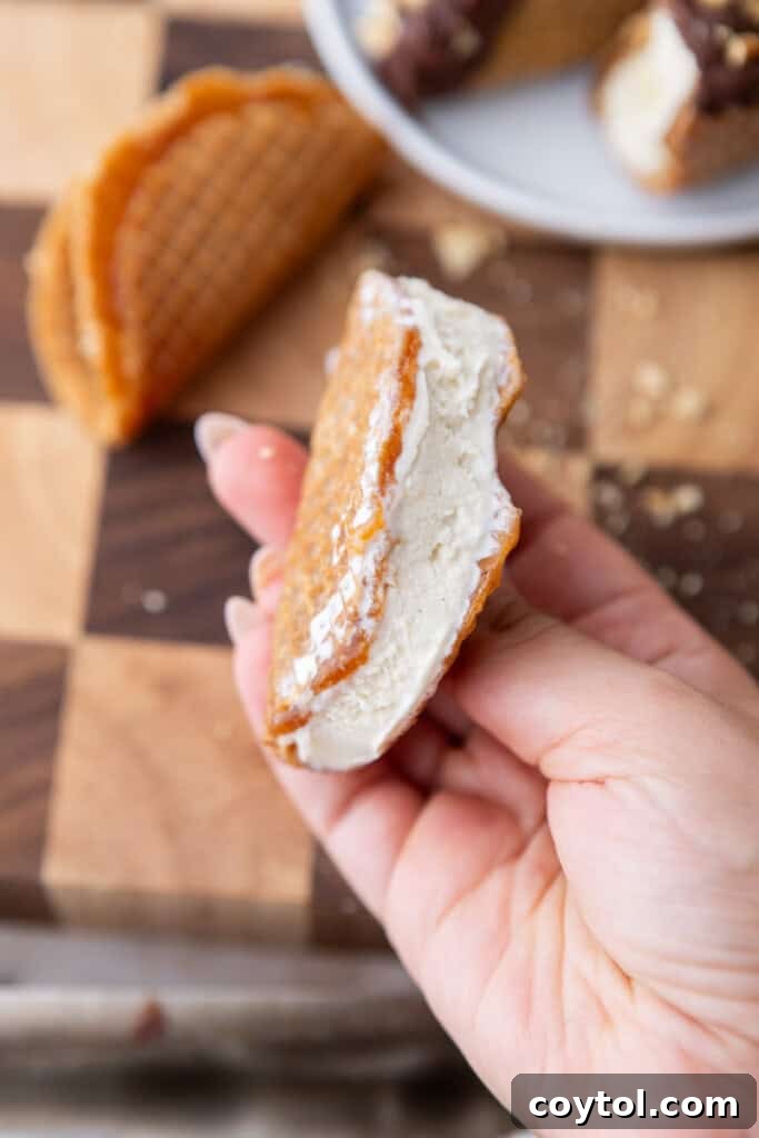 Ultimate Stroopwafel Choco Tacos Caramel Chocolate Perfection 8 A stroopwafel taco shell being filled with a scoop of vanilla ice cream.