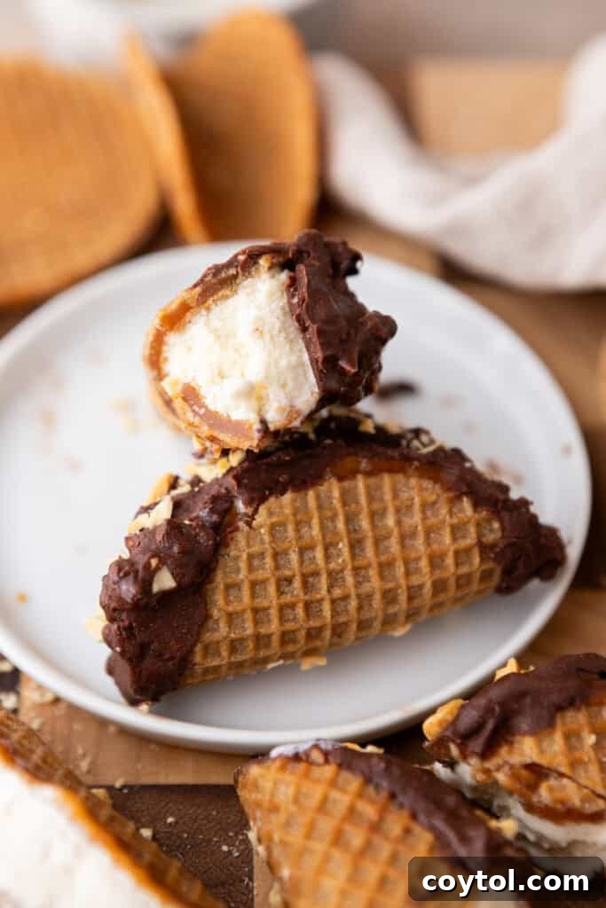 Ultimate Stroopwafel Choco Tacos Caramel Chocolate Perfection 10 A stroopwafel choco taco being dipped into melted chocolate mixed with peanuts.