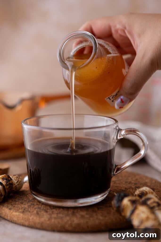 Homemade toasted marshmallow syrup going into a coffee