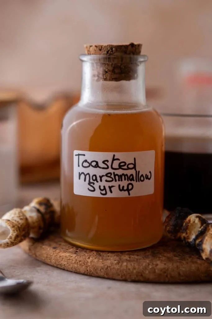 Homemade toasted marshmallow syrup going in a jar