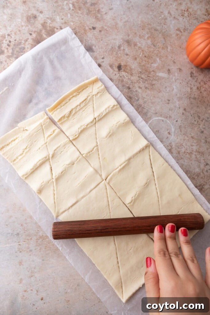 The first can of croissant dough unrolled and flattened in the baking pan, forming the base layer.