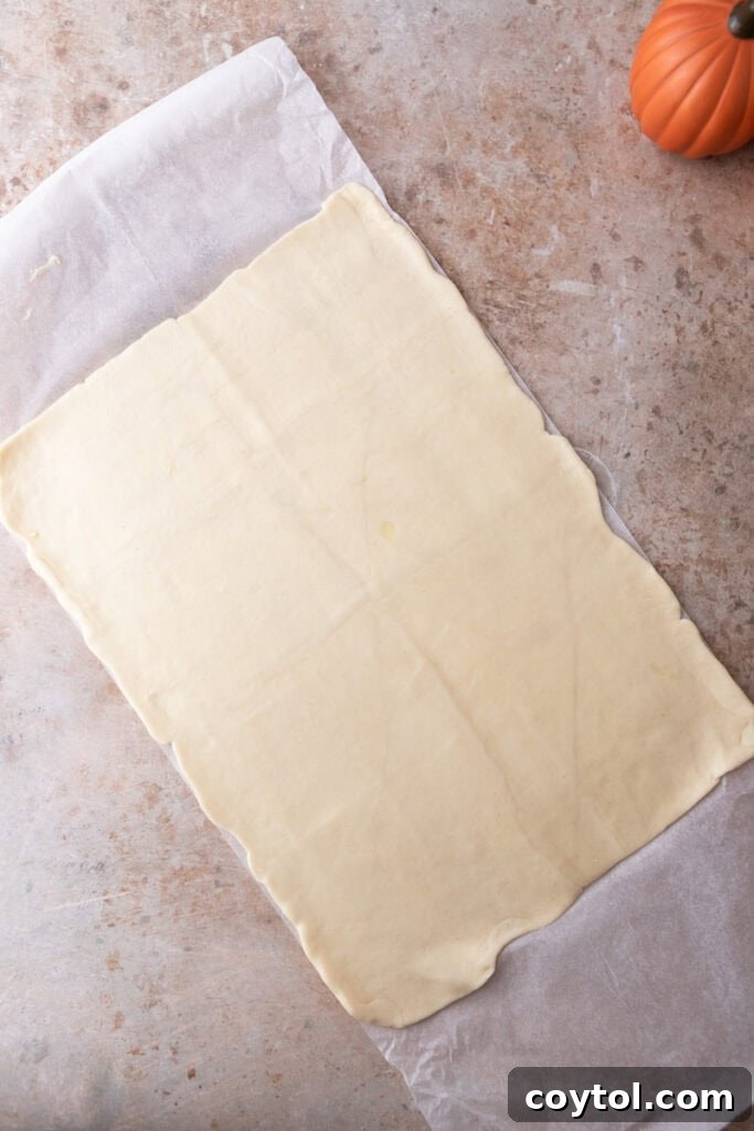Close-up of the pressed-down croissant dough in the baking pan, showing an even base.