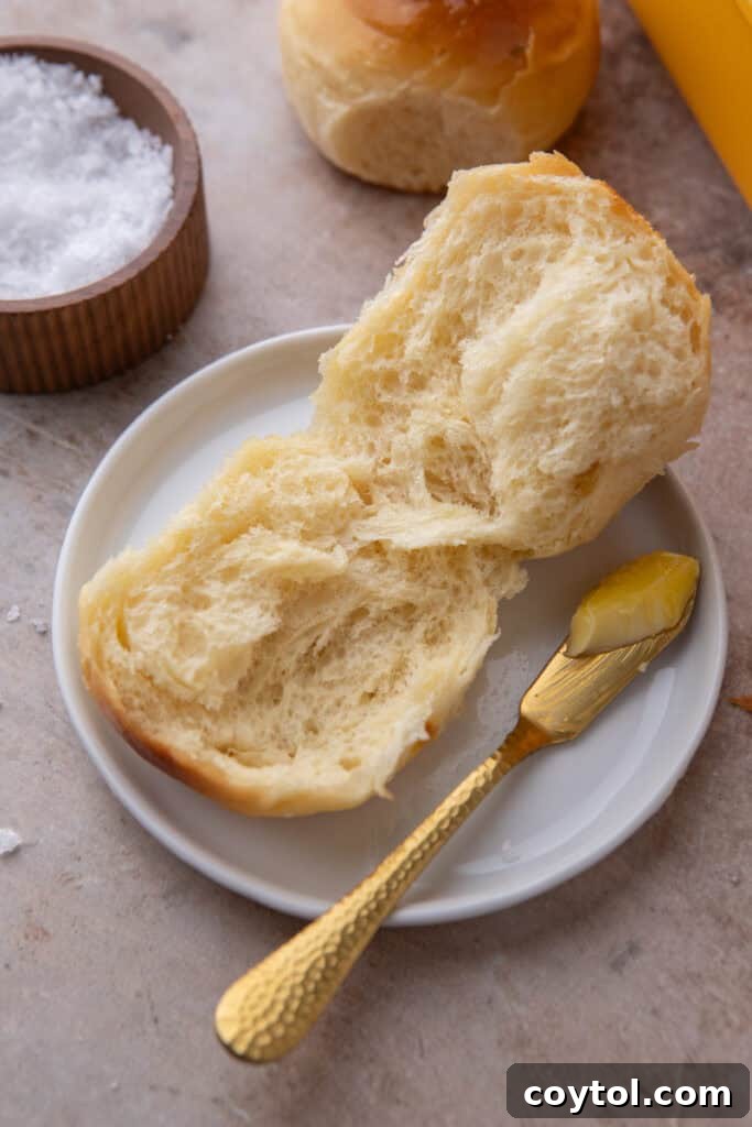 Pillowy Soft Buttery Holiday Rolls 15 Close-up cross-section of a homemade dinner roll, revealing its soft, airy, and fluffy interior texture