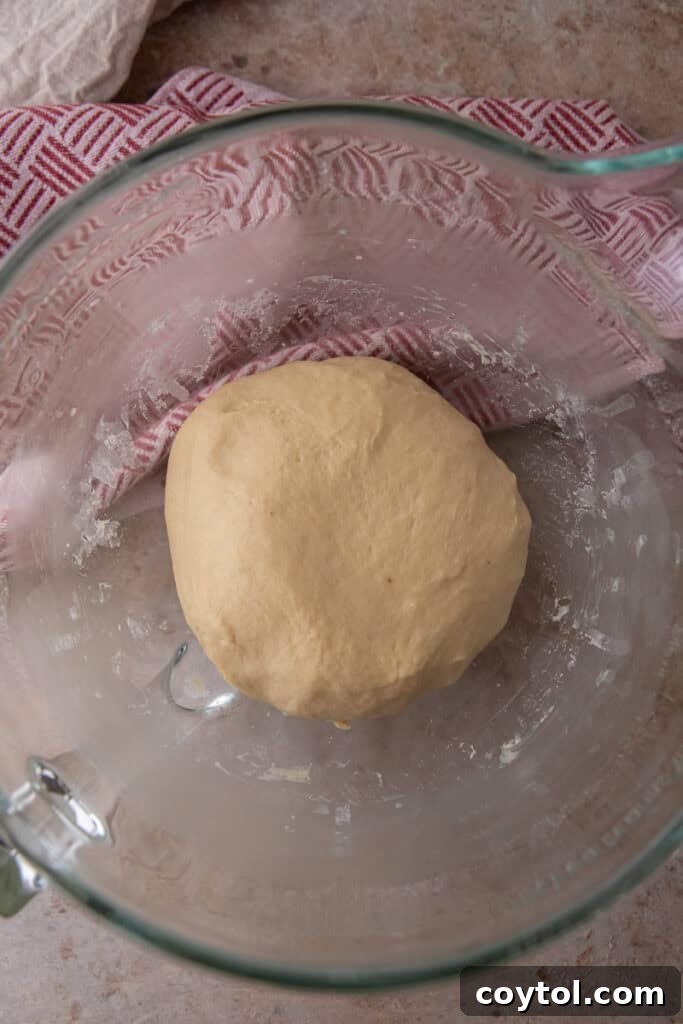 Pillowy Soft Buttery Holiday Rolls 8 Dinner roll dough actively coming together into a soft, cohesive ball during mixing in a stand mixer