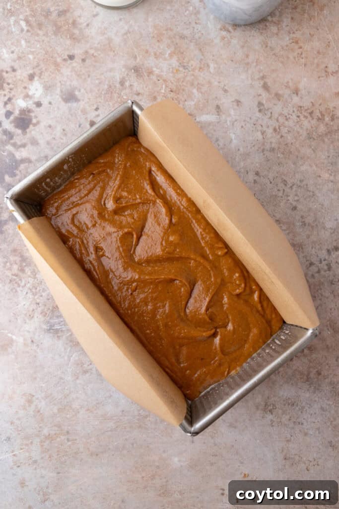 Pumpkin bread batter in a loaf pan, ready for streusel.
