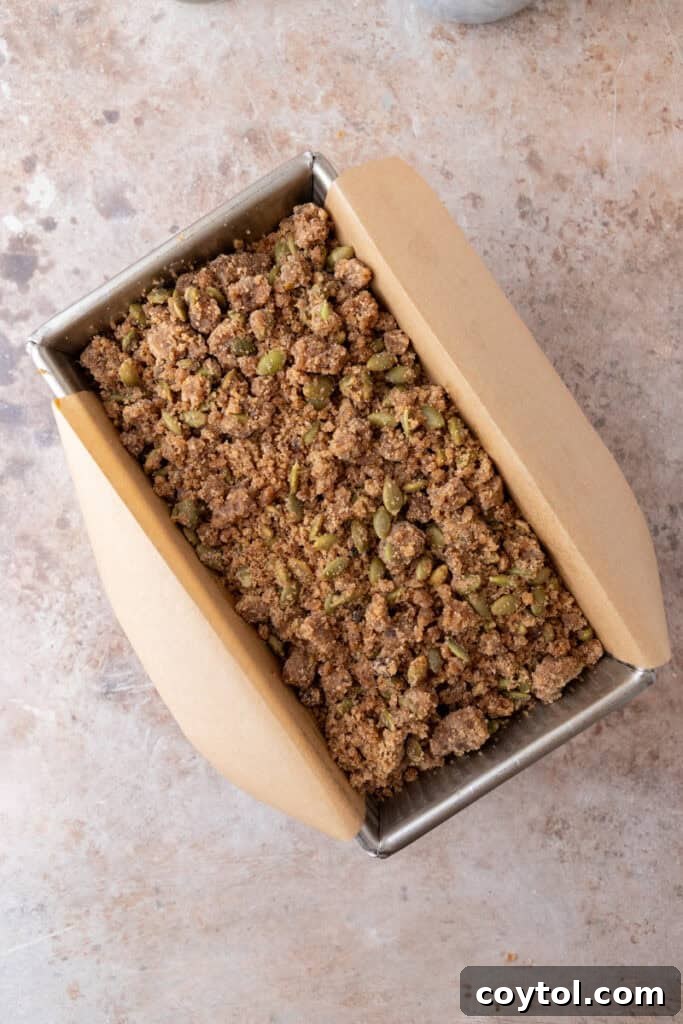 Baked pumpkin bread with streusel in a loaf pan.