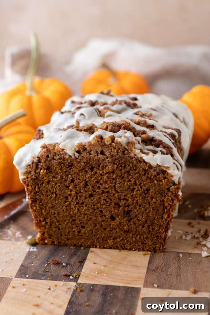Side view of a Streusel Pumpkin Bread, highlighting the distinct layers of bread, streusel, and glaze.