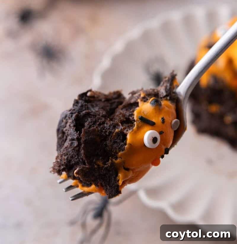 Black Cocoa Cinnamon Rolls with a bite on a spoon