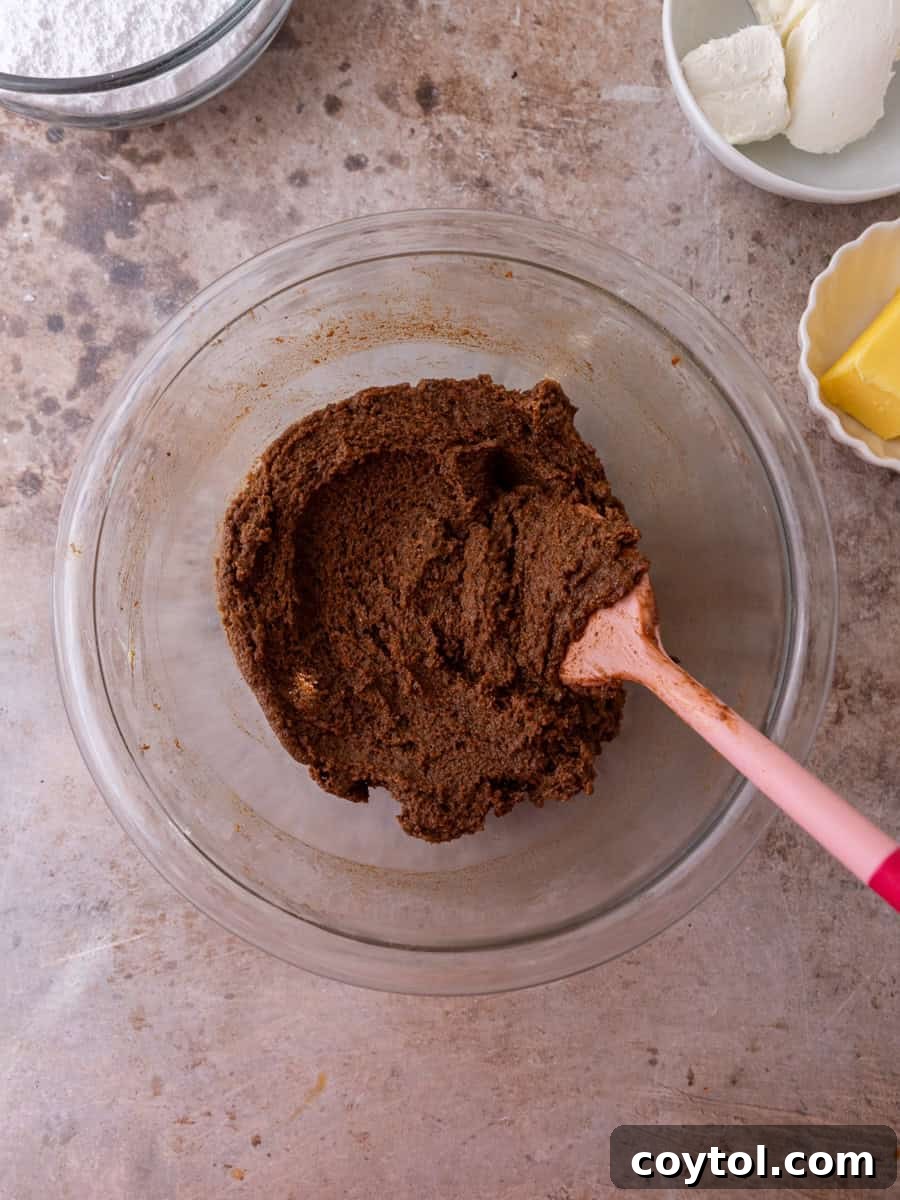 Cinnamon roll brown sugar cinnamon filling in a glass bowl with spatula.