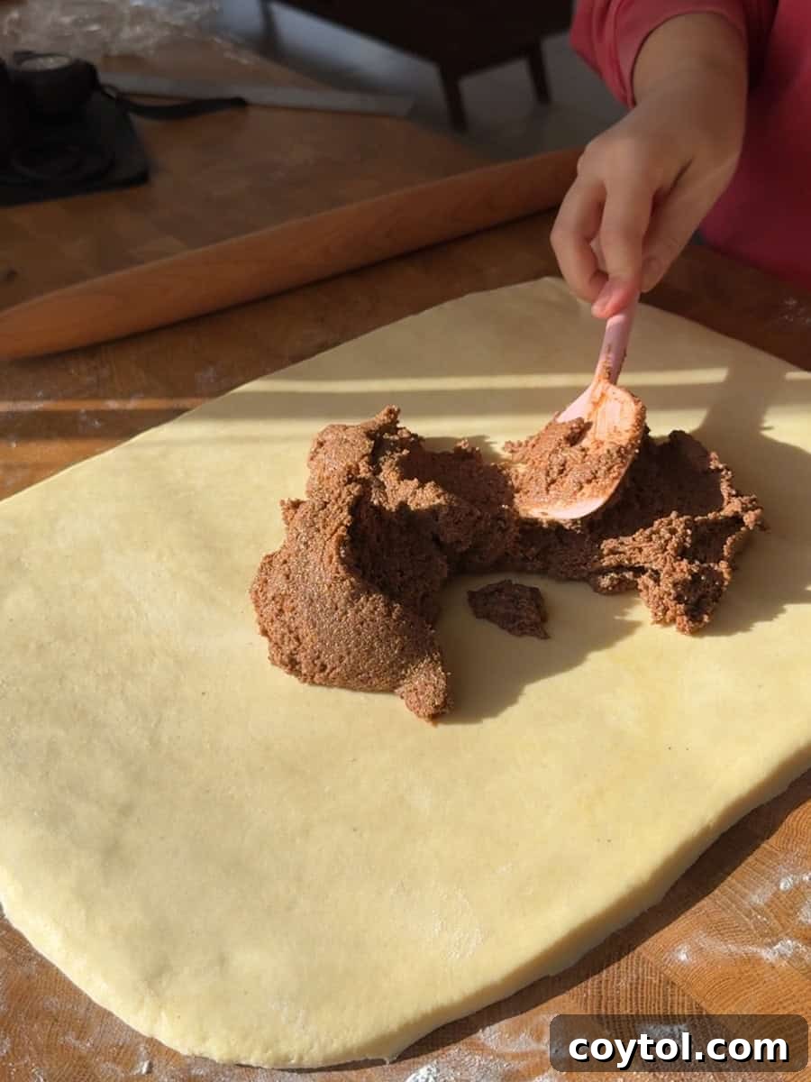  Spreading cinnamon filling over rolled brioche dough