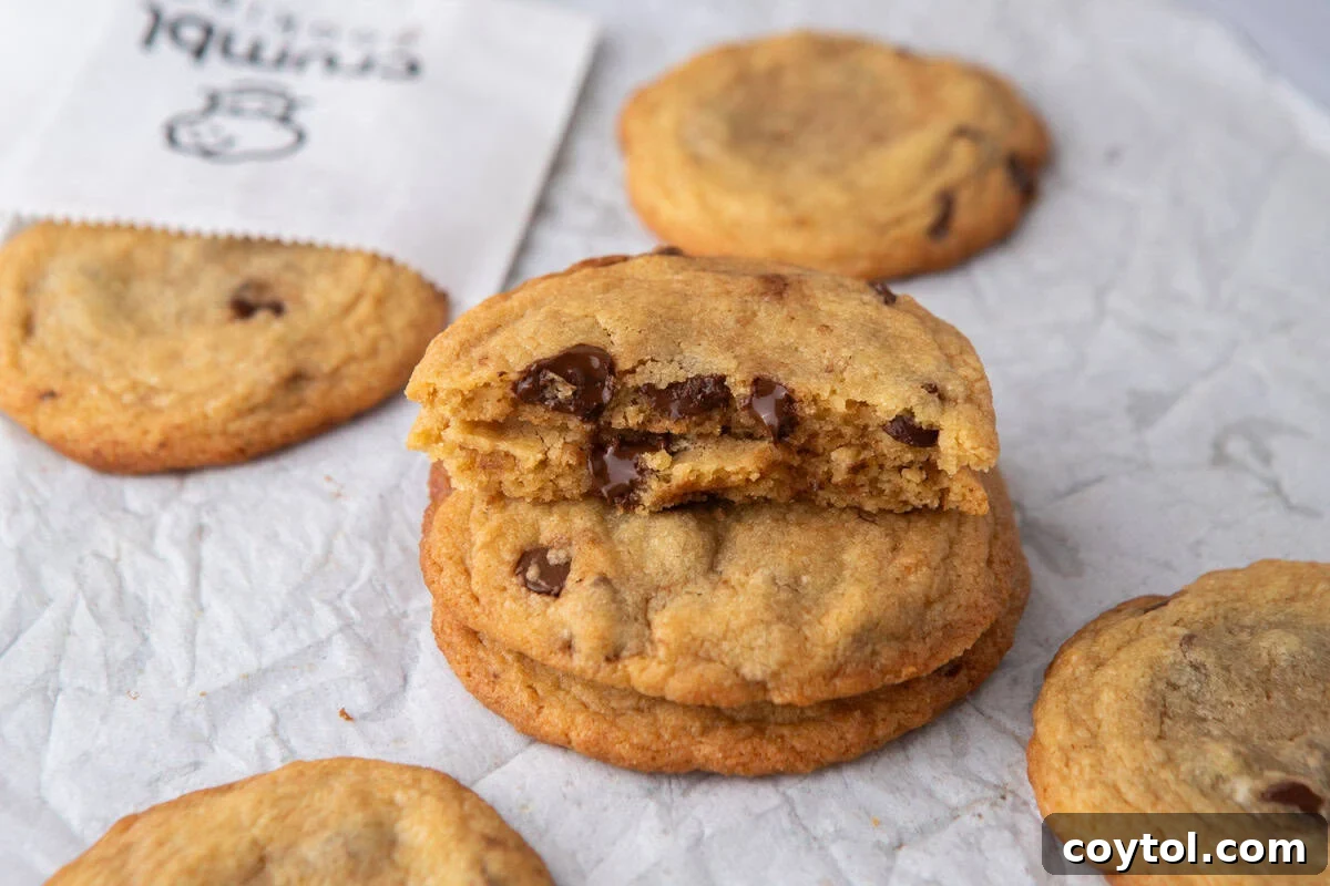 Martha Stewart's Chocolate Chip Cookies Crumbl-Style 2 Stack of thin Crumbl-style chocolate chip cookies with melted chocolate centers and crisp golden edges.