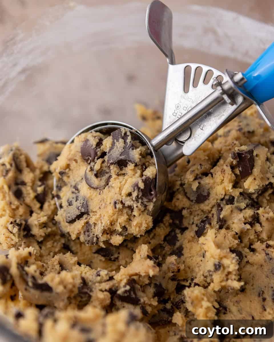 Scooping cream cheese chocolate chip cookie dough with a cookie scoop