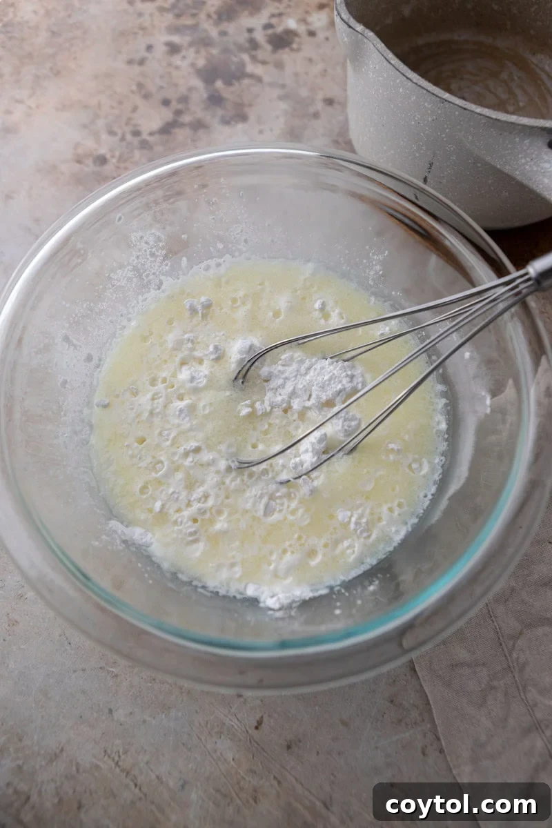 Hot milk mixture poured over tapioca flour in a bowl
