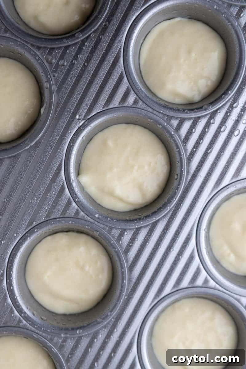 Unbaked Brazilian cheese bread batter portioned in mini muffin tin