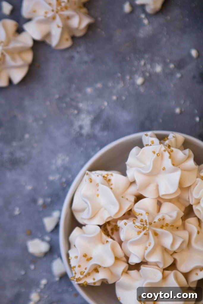 Close-up of a stack of simple, elegant vanilla meringue cookies, showcasing their delicate texture.