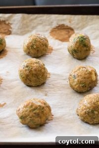Indian Chicken Meatballs baking on parchment paper on a baking sheet