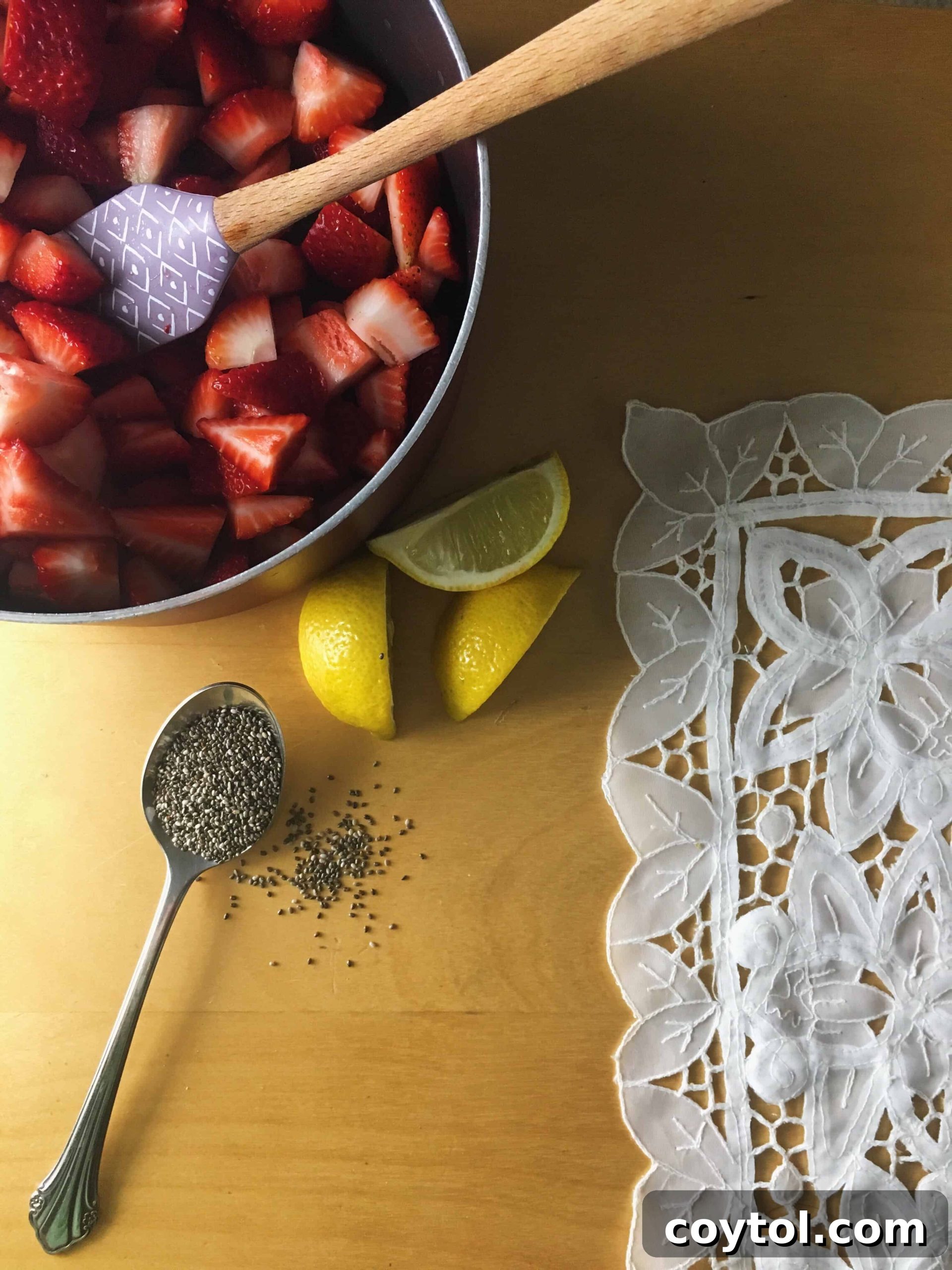 Sliced strawberries, vanilla pod, and lemon for a homemade sugar-free jam recipe