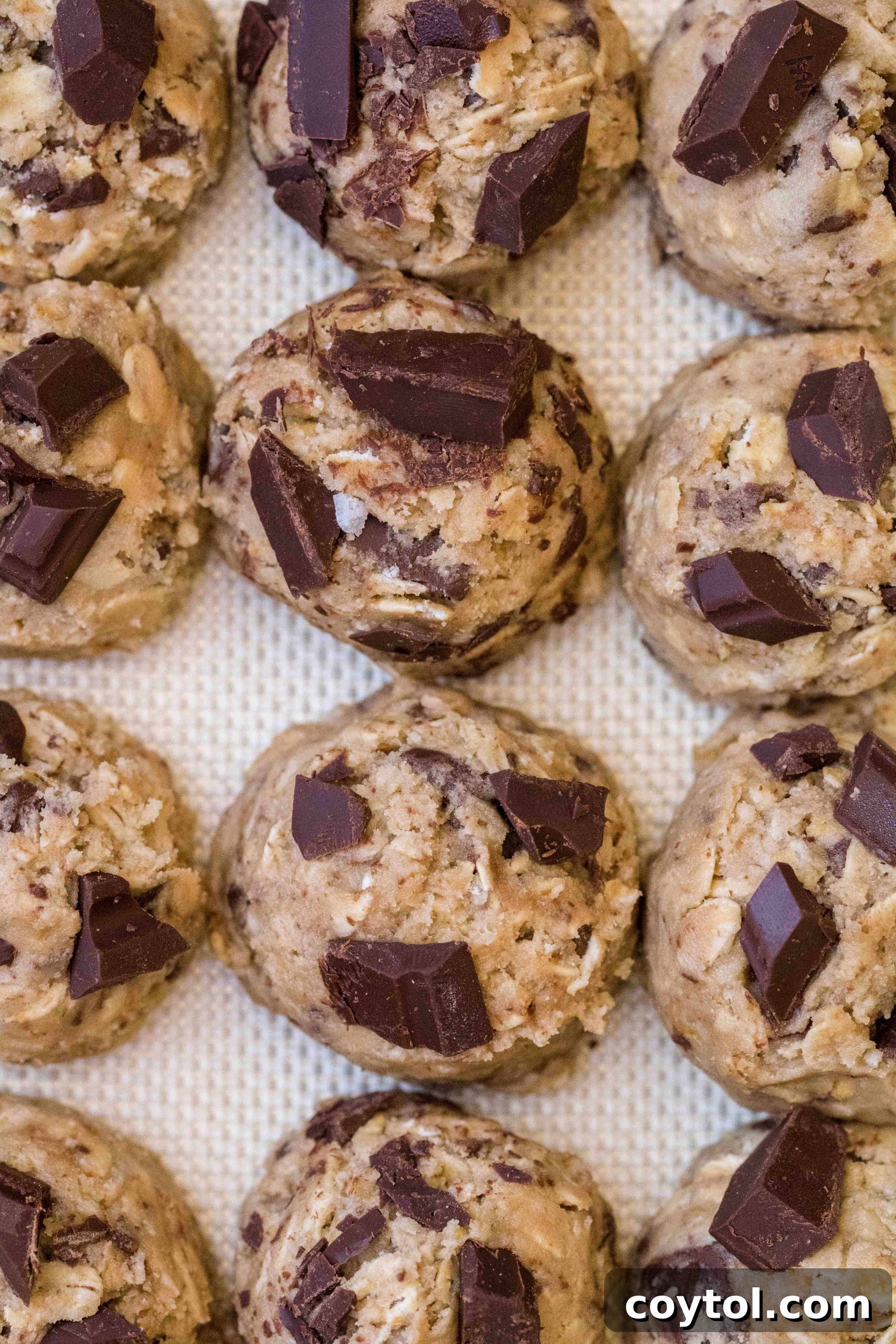 Irresistibly Soft and Chewy Chocolate Chip Oatmeal Cookies 6 How to make soft and chewy oatmeal chocolate chunk cookies, showing cookie dough balls on a baking sheet.