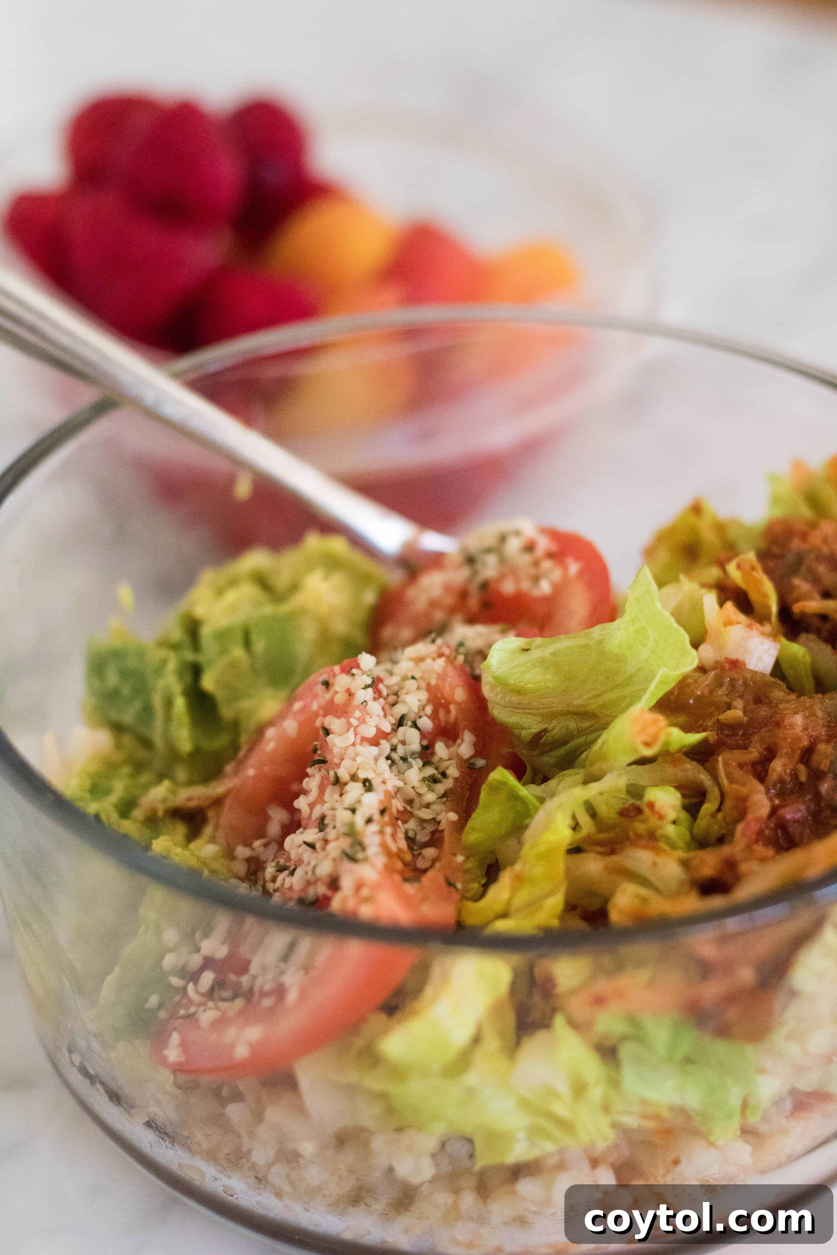 Vibrant vegan gut-healing Buddha bowl with fresh ingredients, topped with spicy kimchi and hemp seeds for a quick and healthy lunch idea.