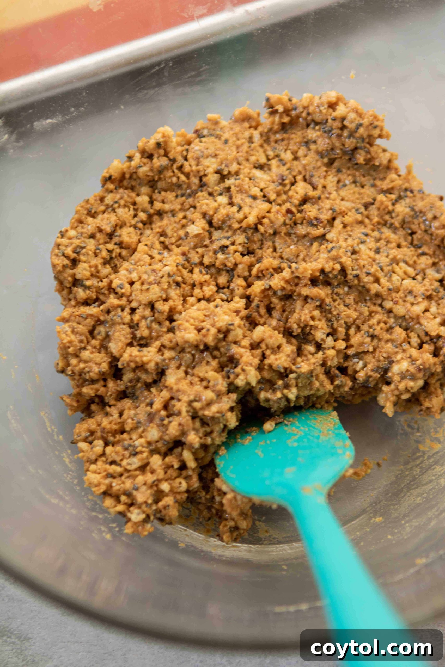 Close up of peanut butter rice cereal mixture, ready to be rolled