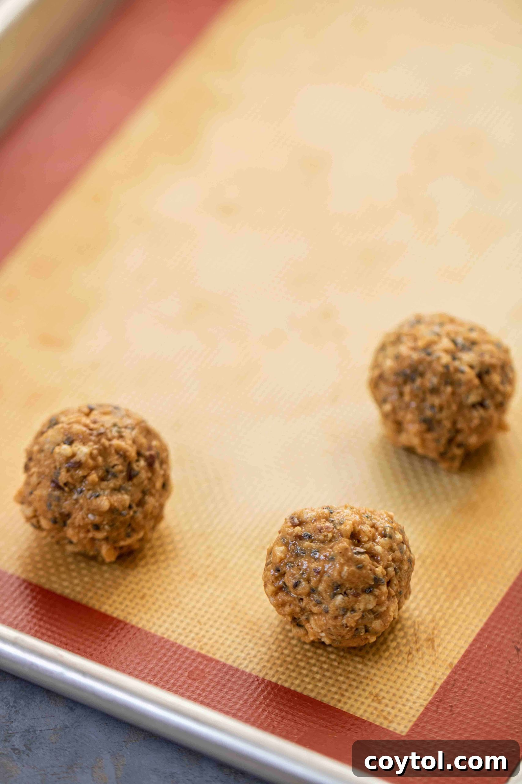 Chia seed peanut butter balls on a baking sheet, ready for freezing