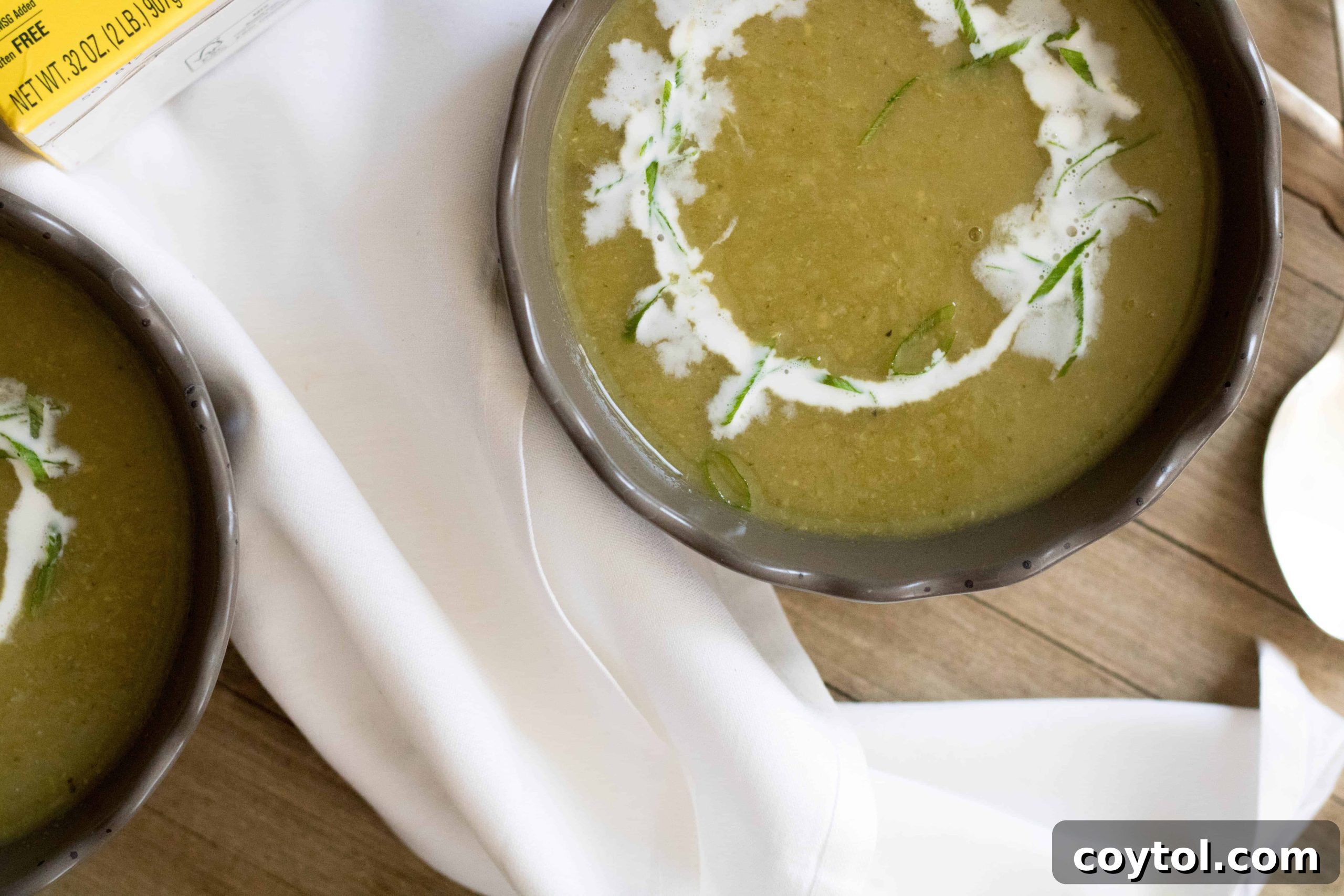 A beautifully presented bowl of creamy green zucchini soup with optional toppings.
